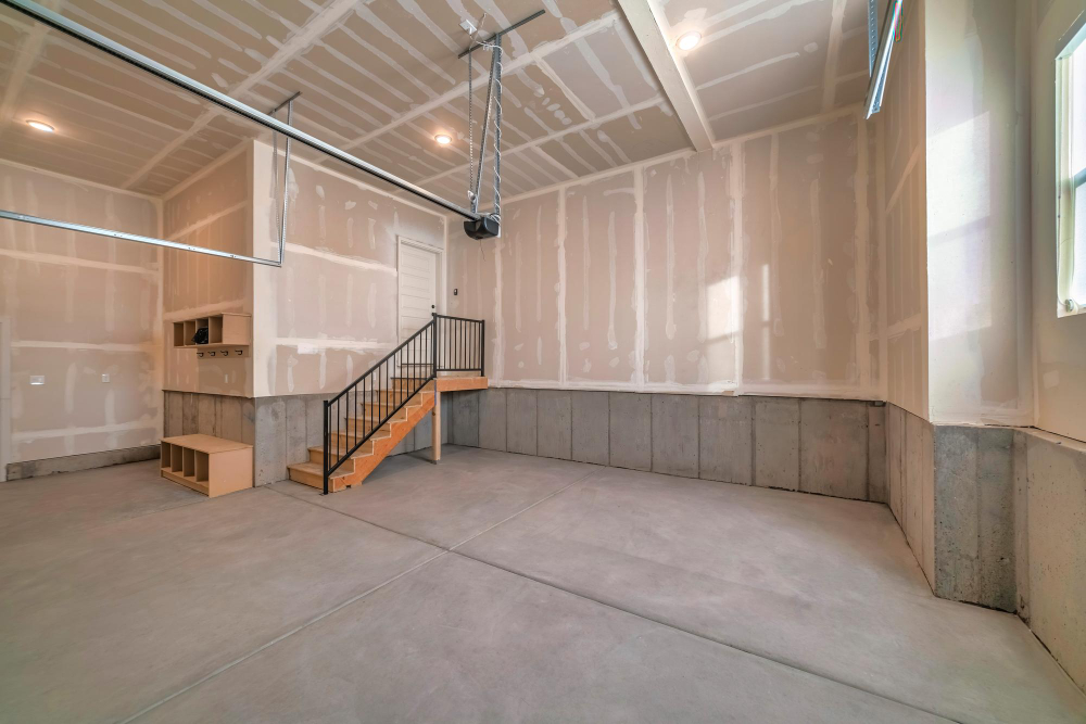 Basement under construction with drywall installation and concrete floors