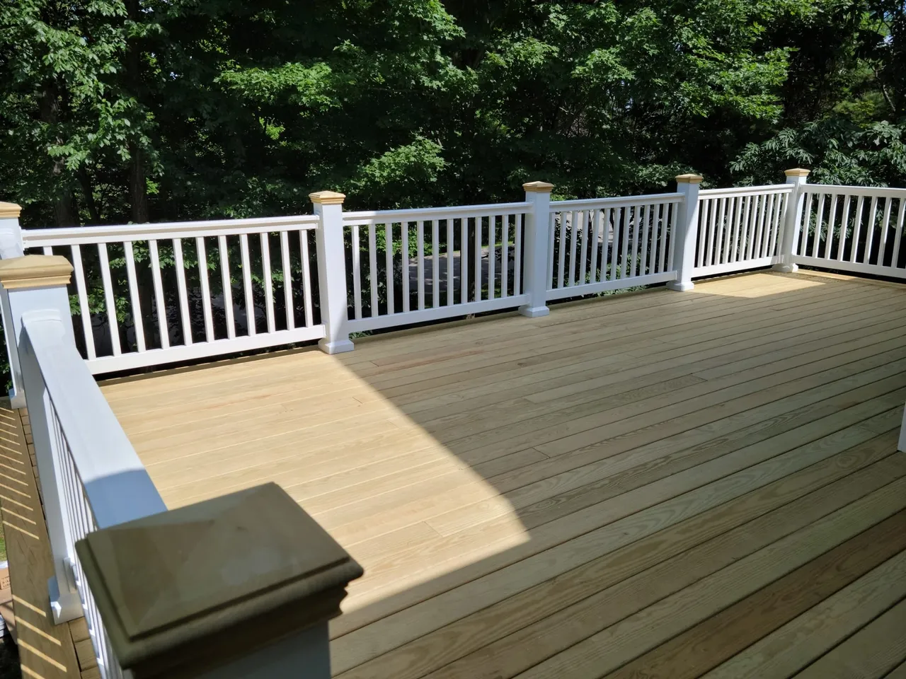 Outdoor deck with white railings and beige composite decking