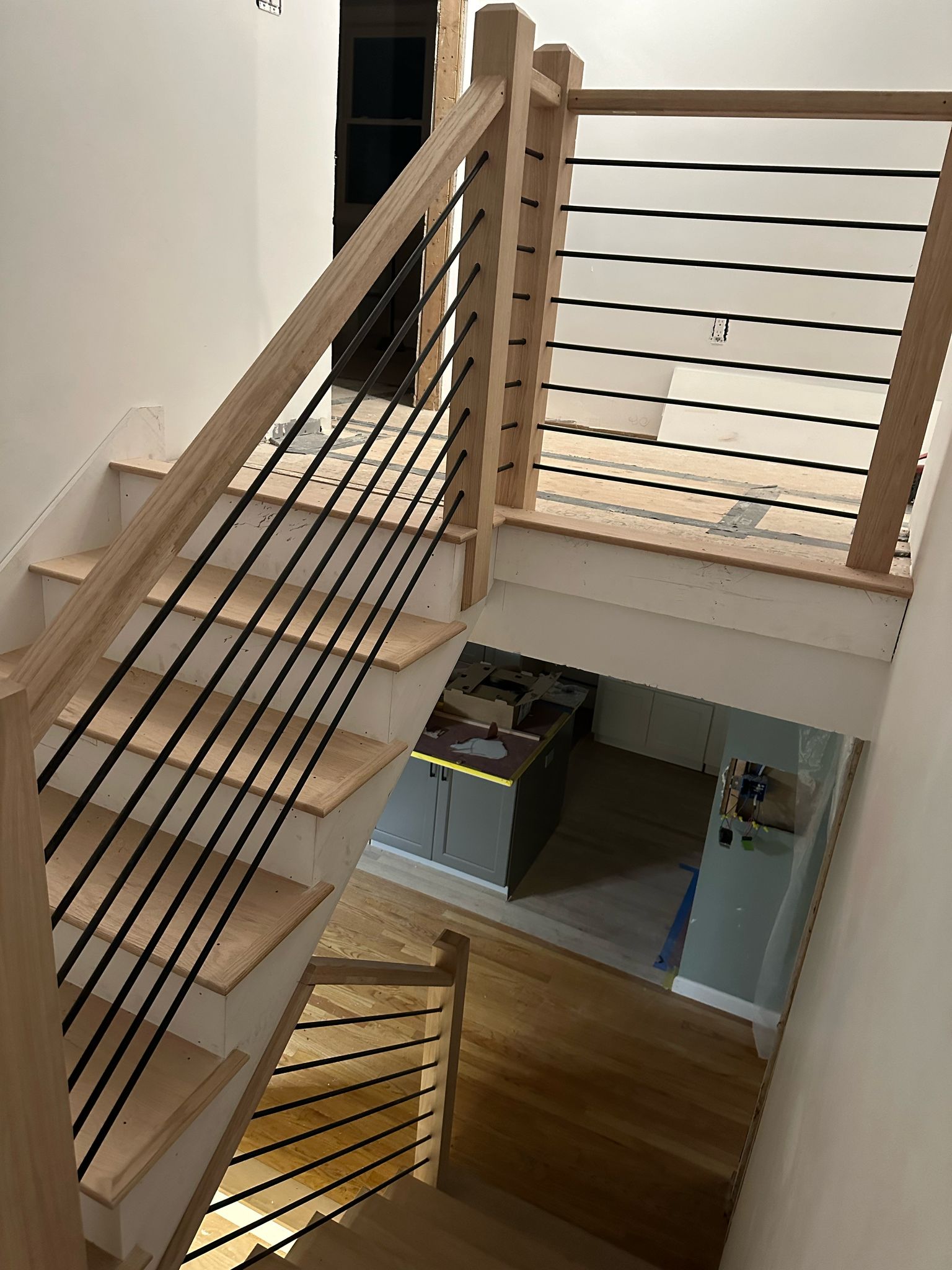 Modern staircase with wooden posts and black metal railings