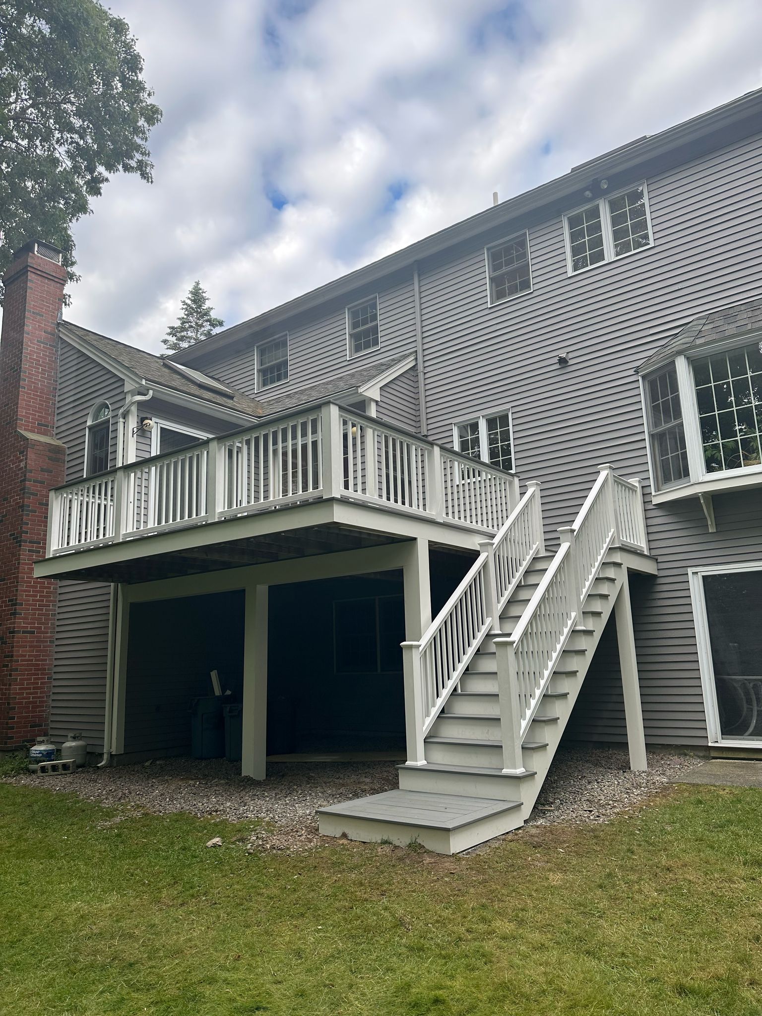 Elevated deck with white railings and stairs to backyard