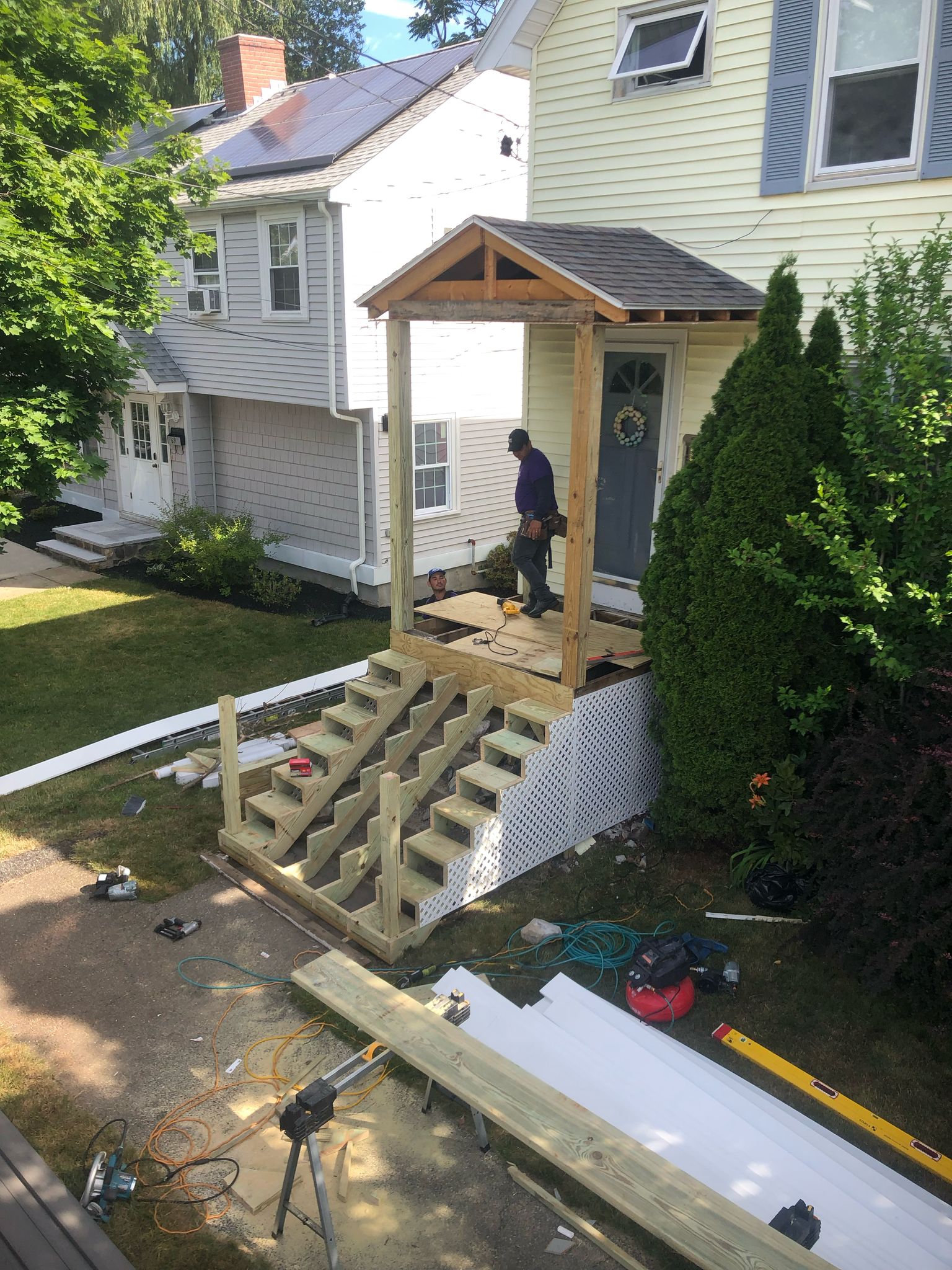 Deck construction in progress with framing for front porch