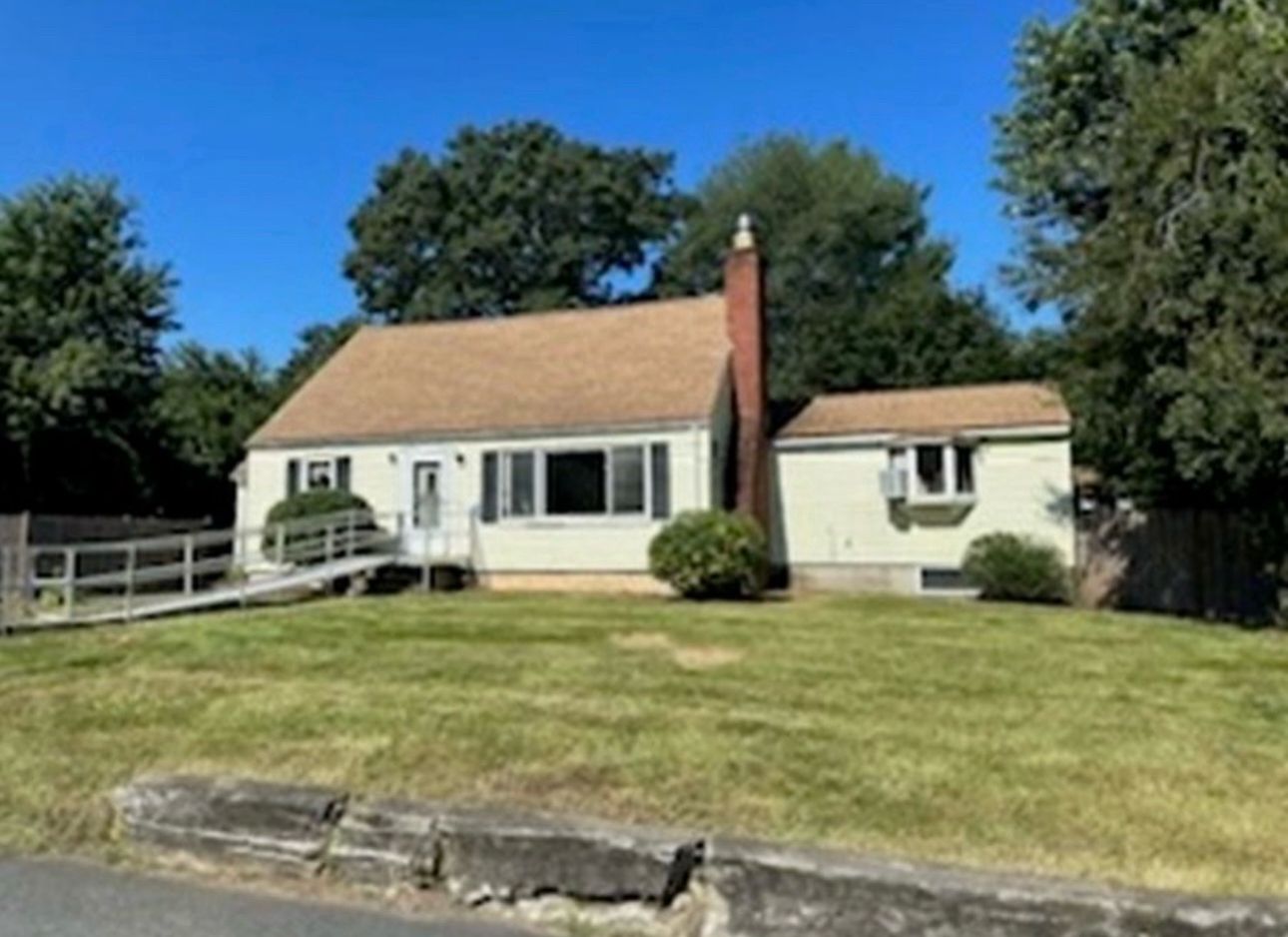 White ranch house before renovation with large front yard