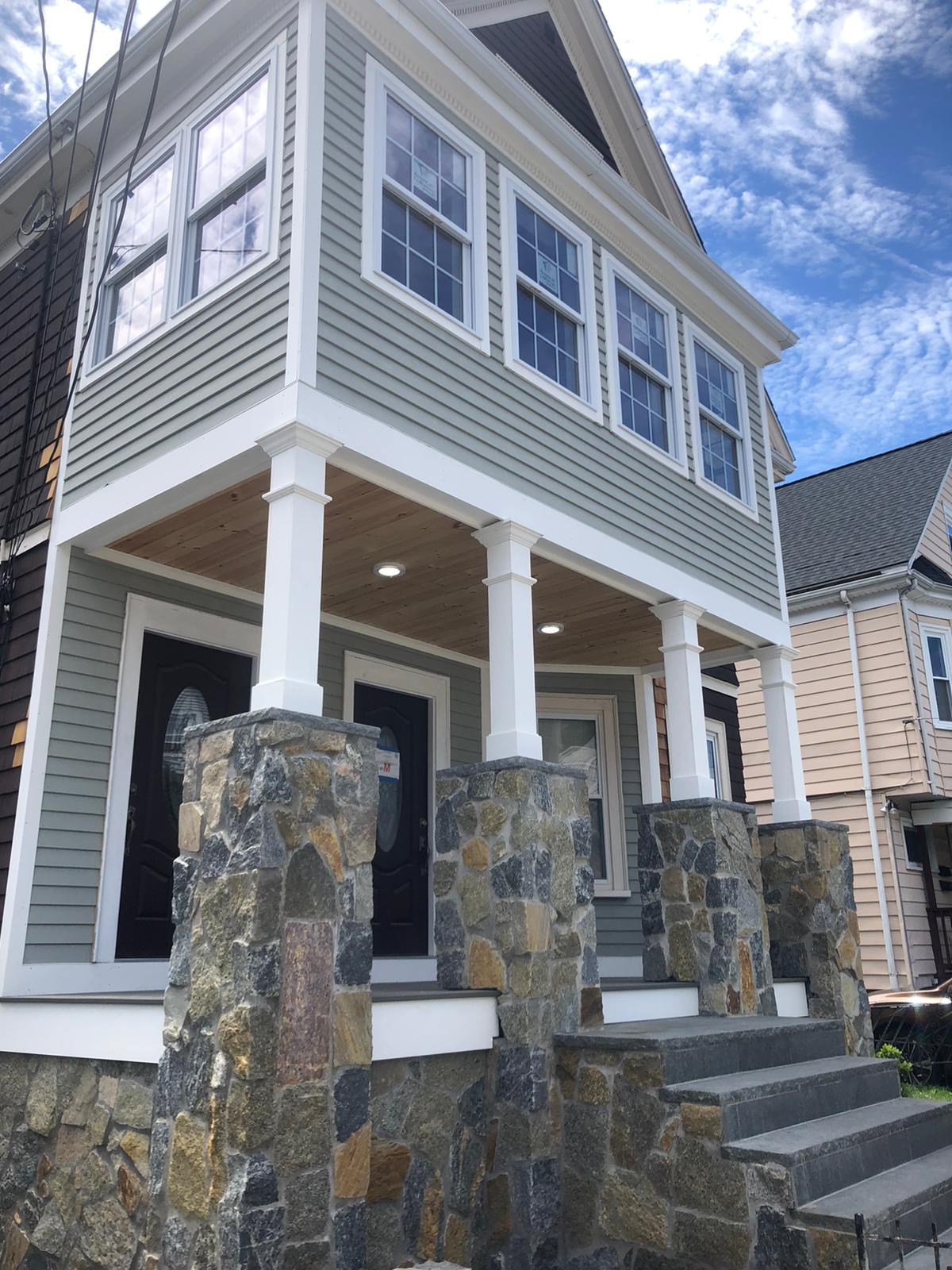 Completed home exterior with stone columns and covered porch