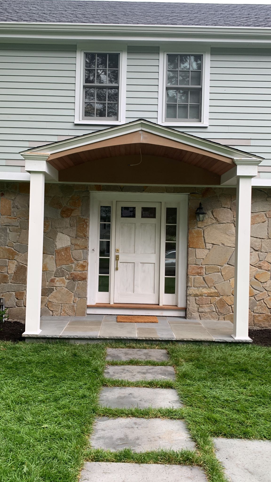 Finished front entrance with stone facade and white door
