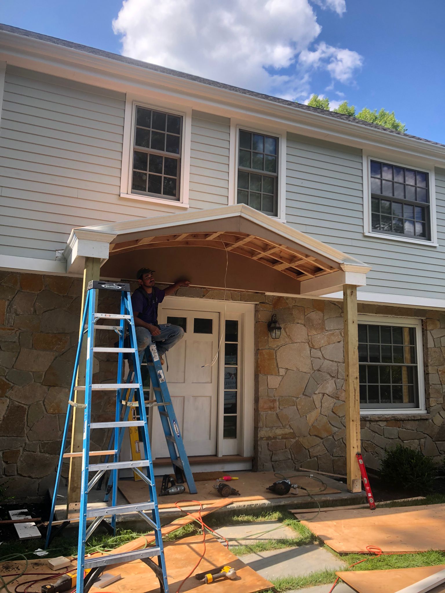 Covered entrance construction with curved archway framing