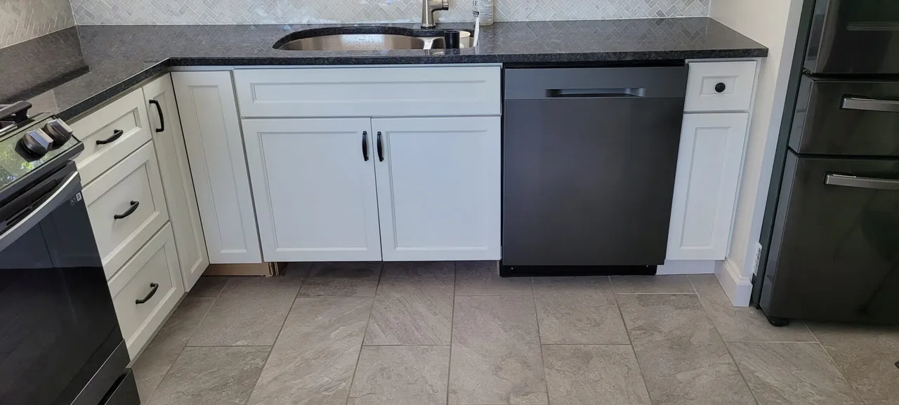 Contemporary kitchen with white cabinetry, black granite countertops, and tile flooring