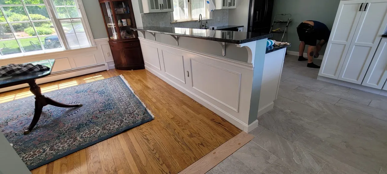 Custom kitchen island with mixed hardwood and tile flooring transition