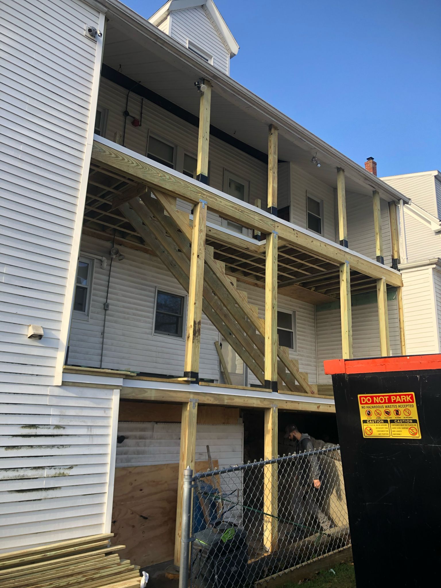 Three-story deck addition with white railings on back of residential home