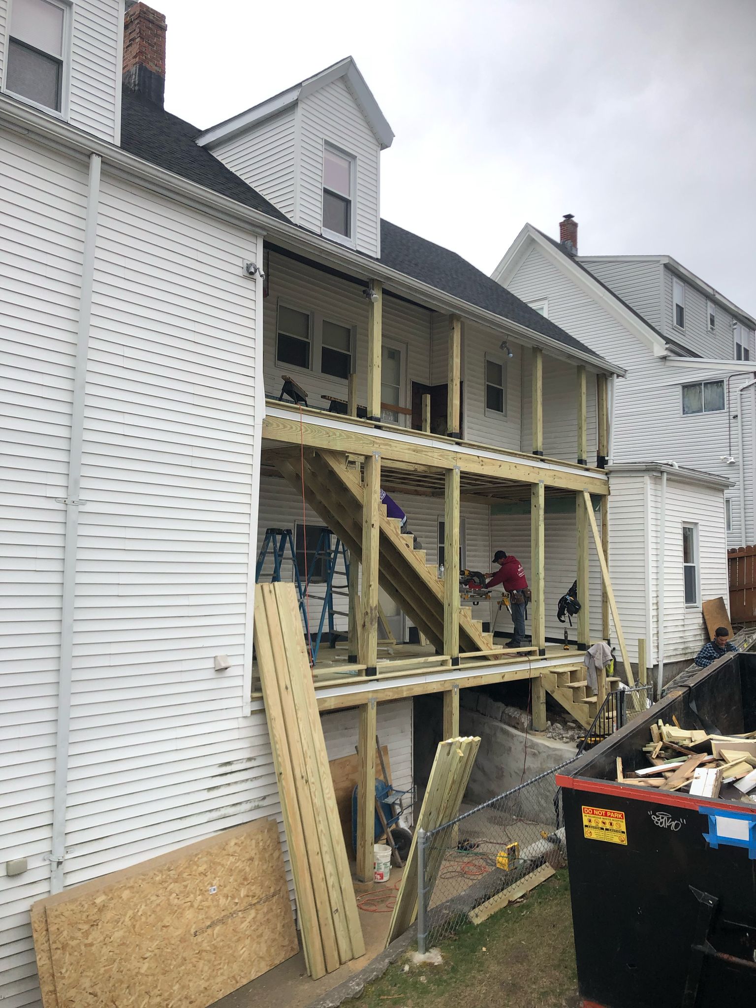 Multi-level deck construction showing wooden framing on back of house