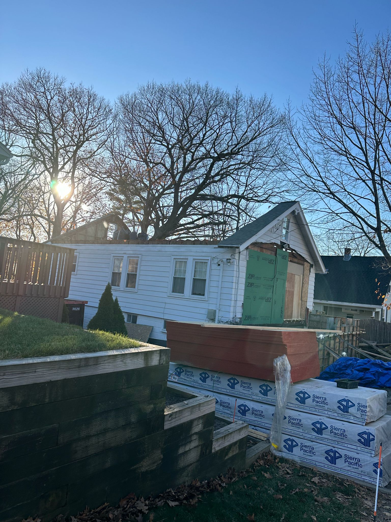 Home addition under construction with green ZIP sheathing and foundation work