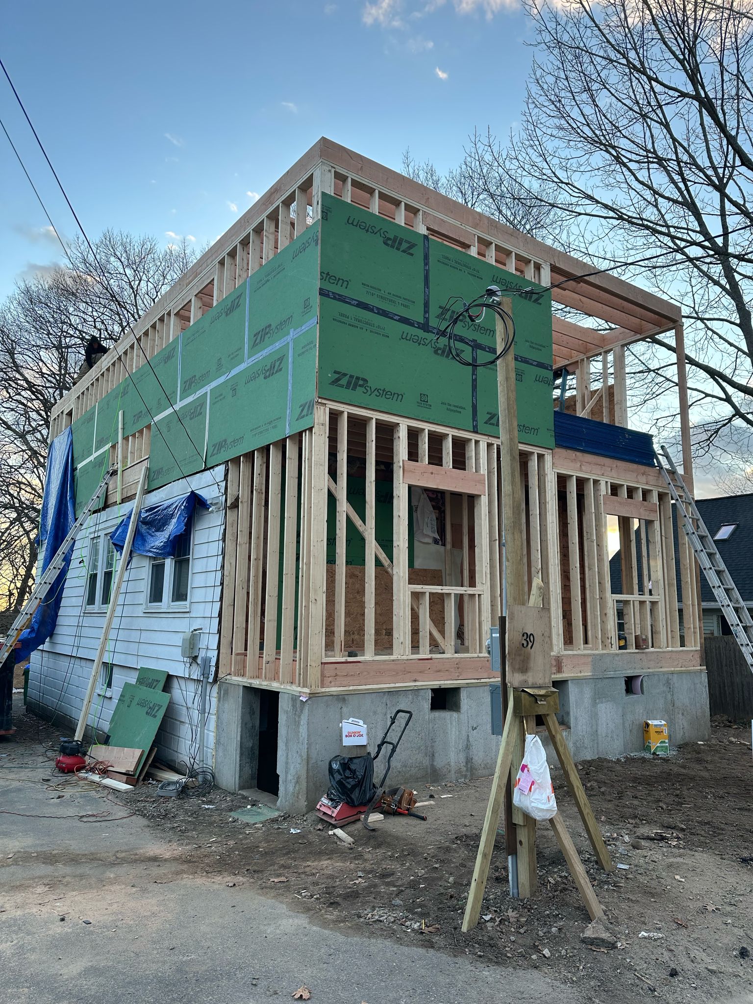 Large home addition with green ZIP system sheathing showing structural framing